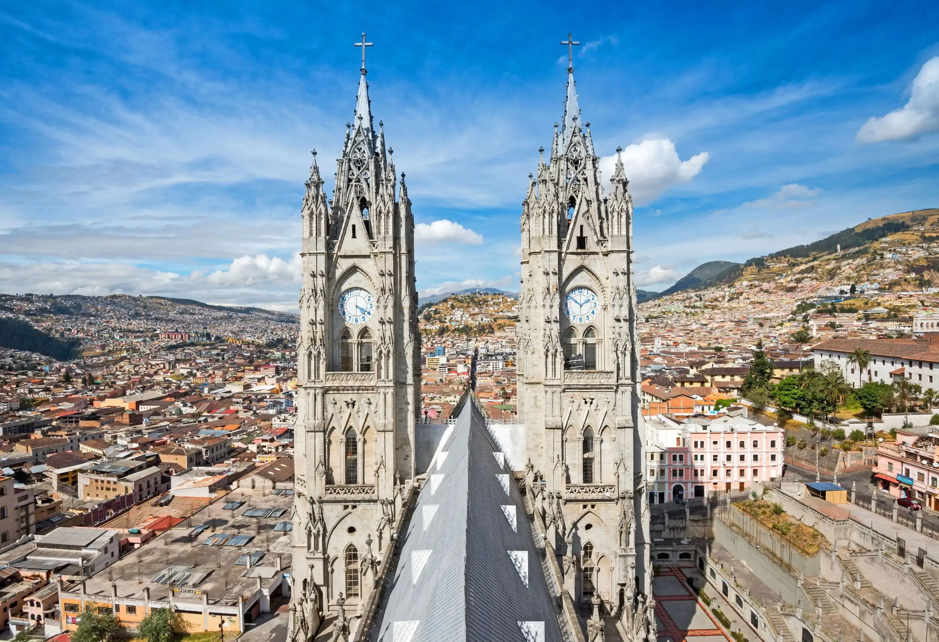 A twin steeple of a Neogothic church protrudes above the roof, dominating the crowded populous city.