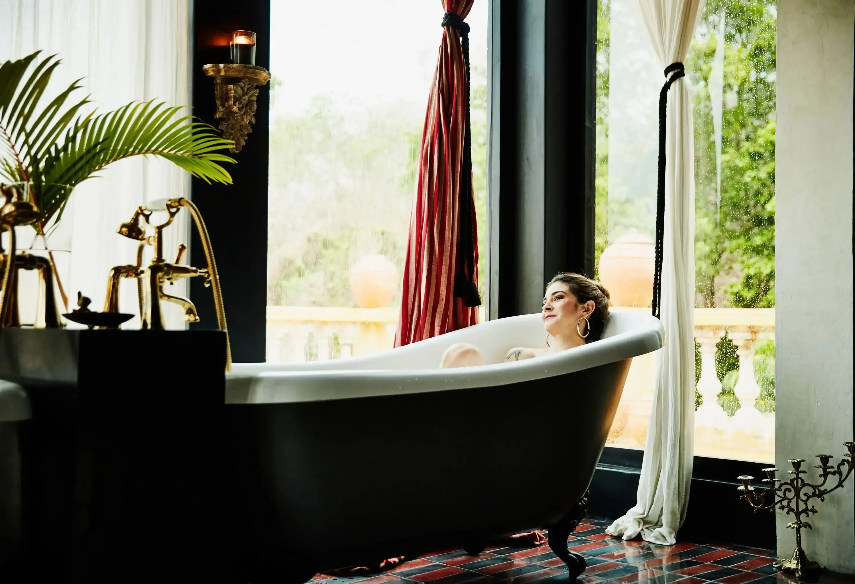 A woman unwinding in a modern clawfoot bathtub.
