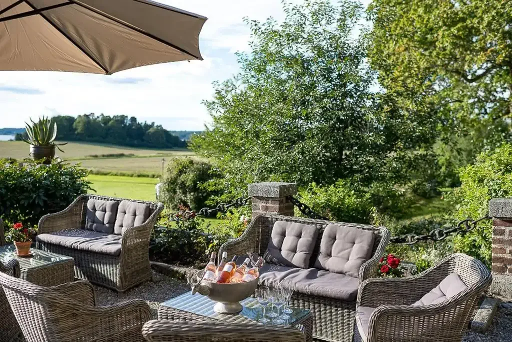 Lounge garden furniture by a large meadow, part of a luxury hotel