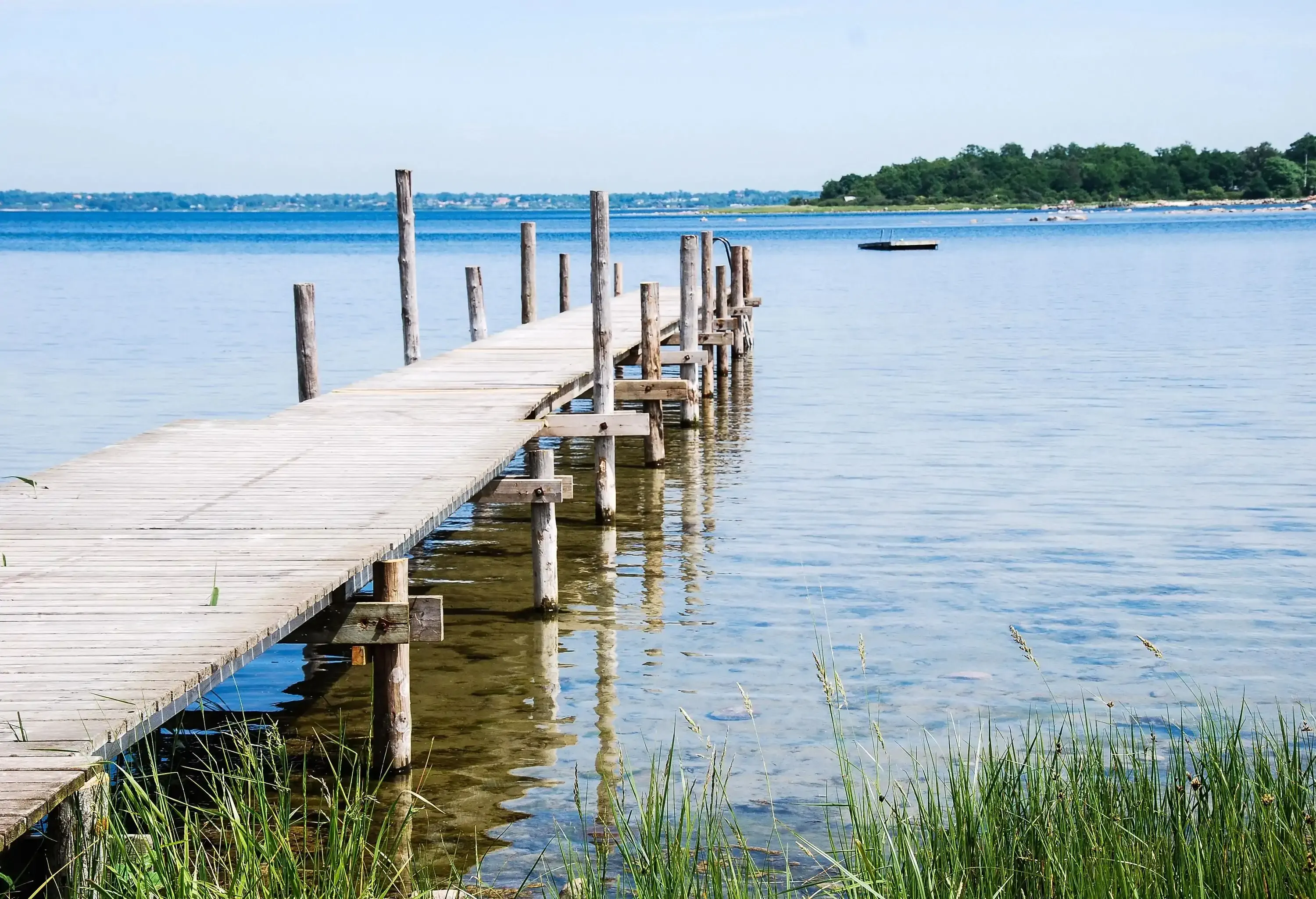 A wooden pier in shallow coastal waters.