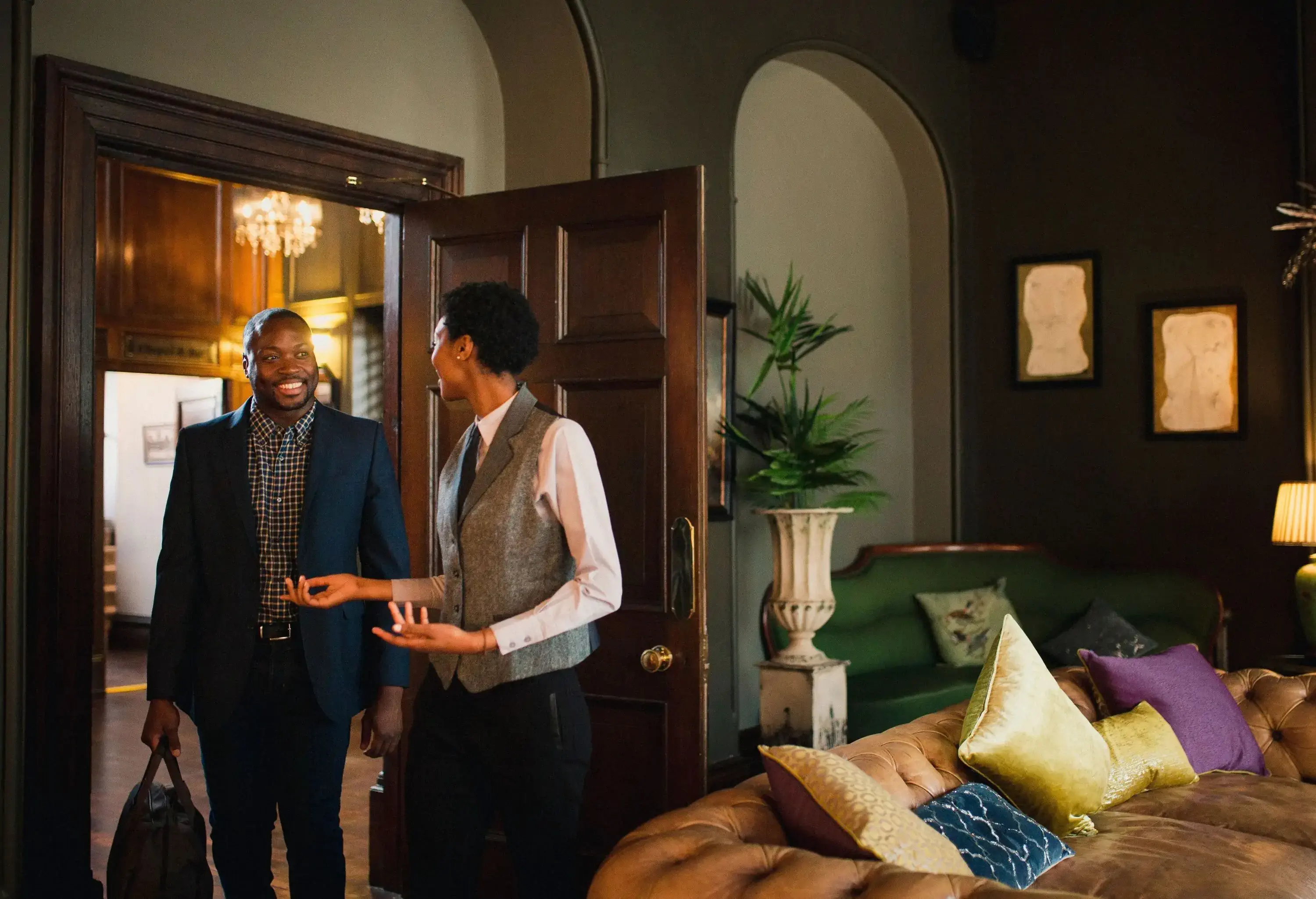 Businessman arrives at luxury hotel and is greeted by the hotel receptionist.