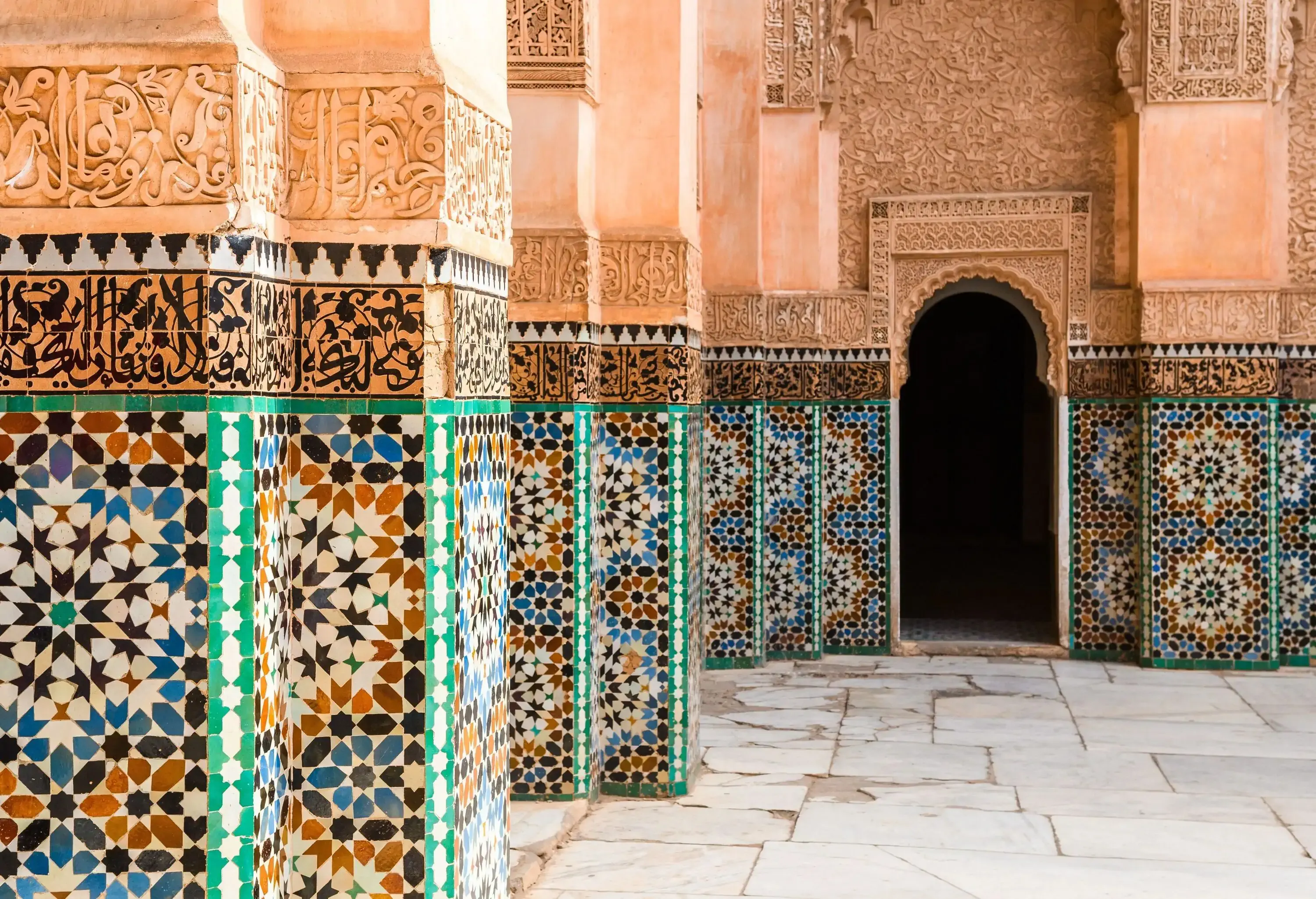 A striking tilework and carvings on the walls of a Moorish building.