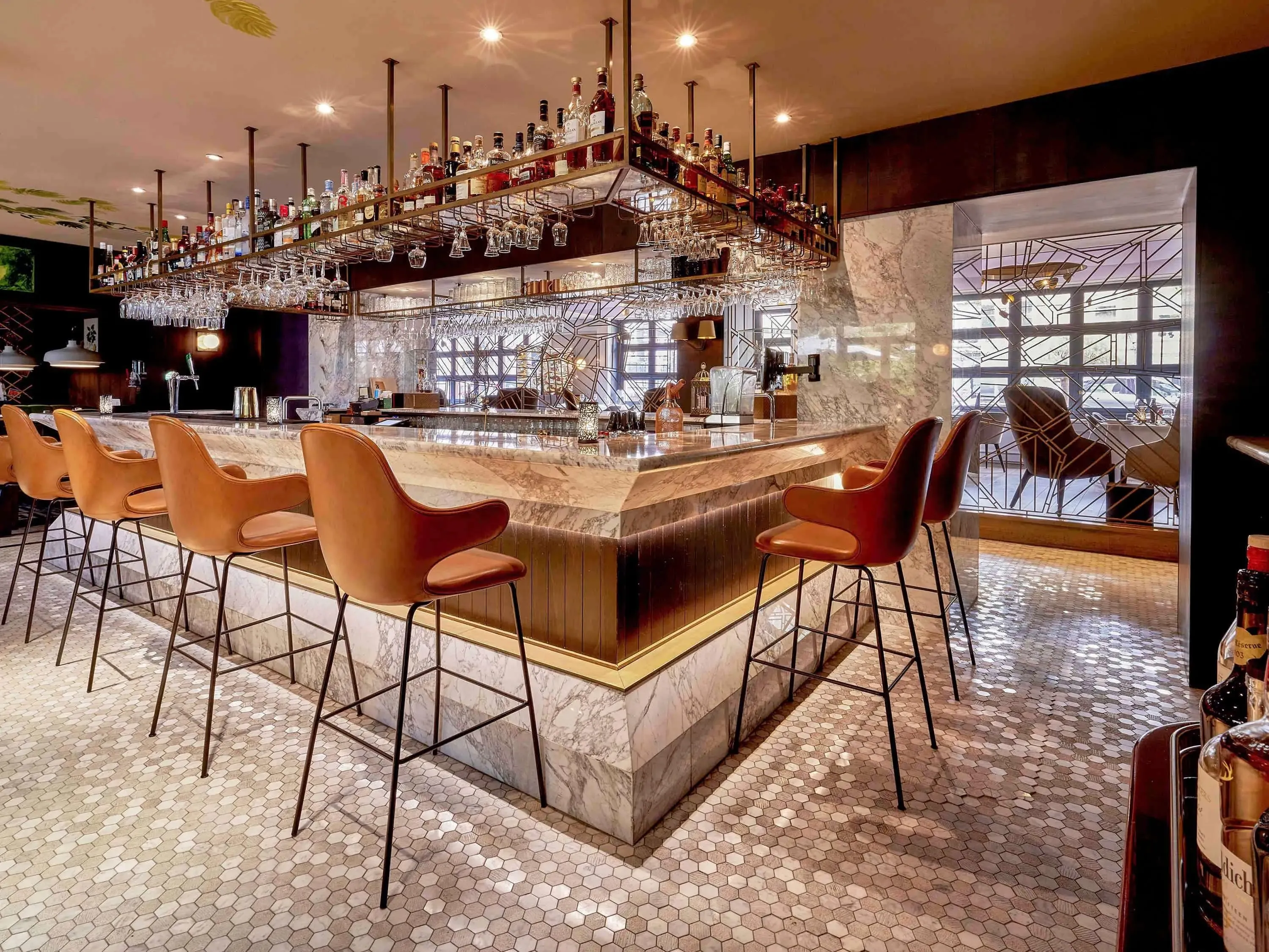 Contemporary hotel bar with suede stools surrounding a well lit bar