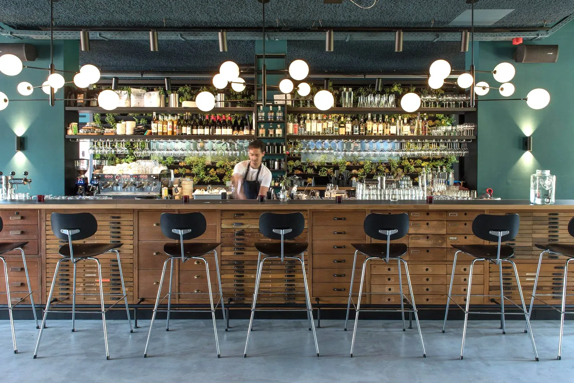 Retro style hotel bar with server behind a bar made of vintage display cabinets