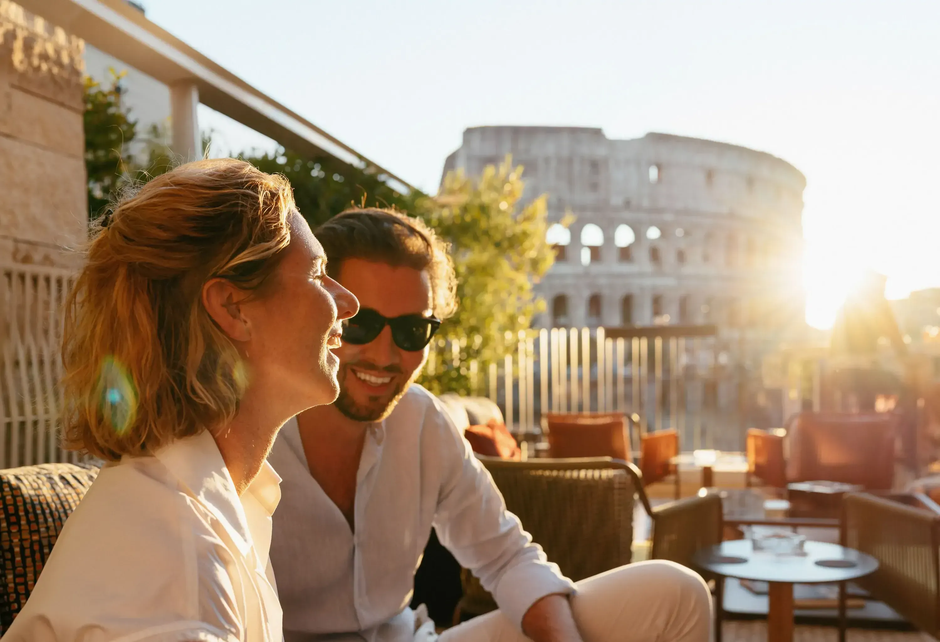 Couple enjoys sunset views of the Colosseum. Romance, travel.