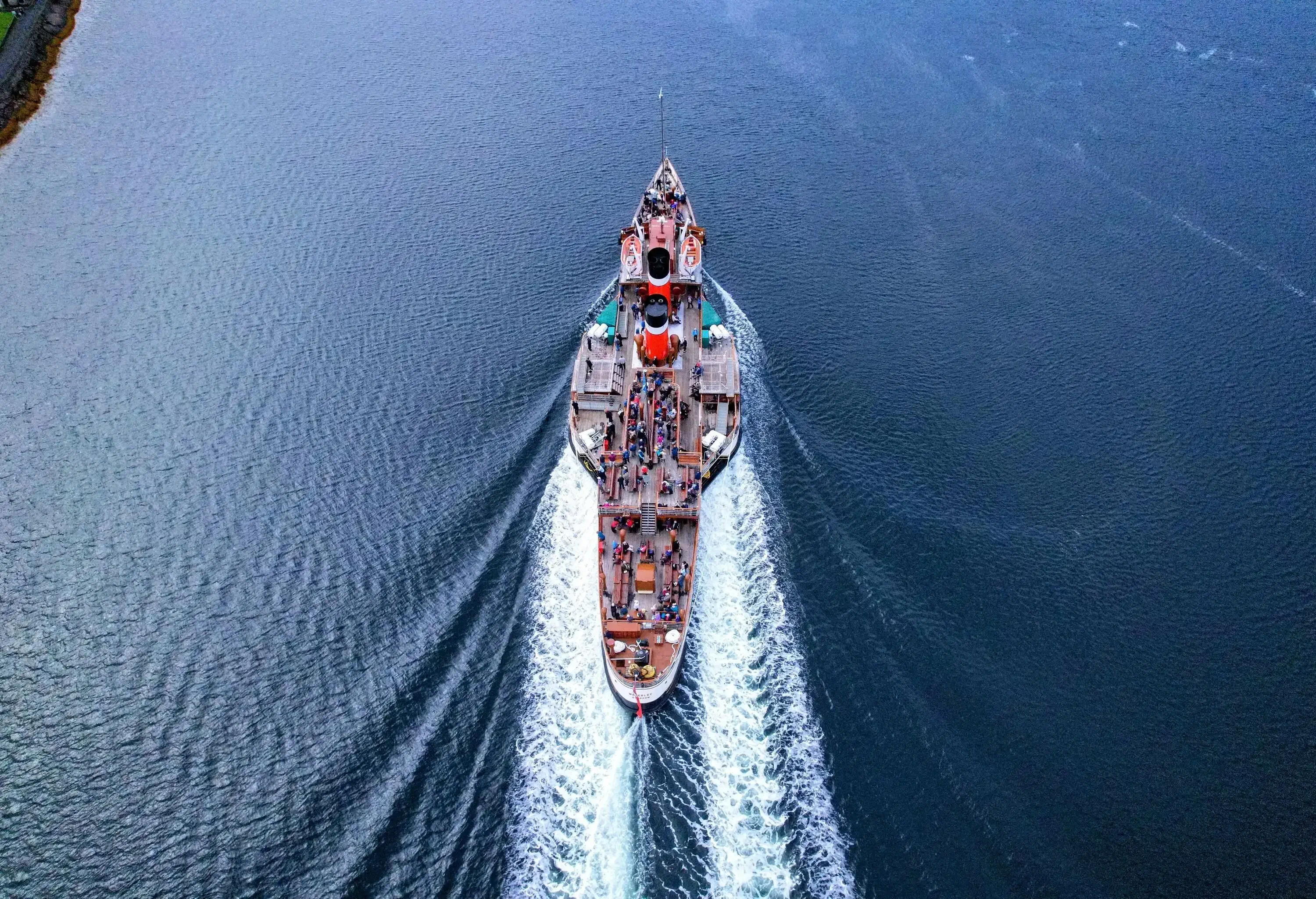 A speeding passenger boat in a bay.